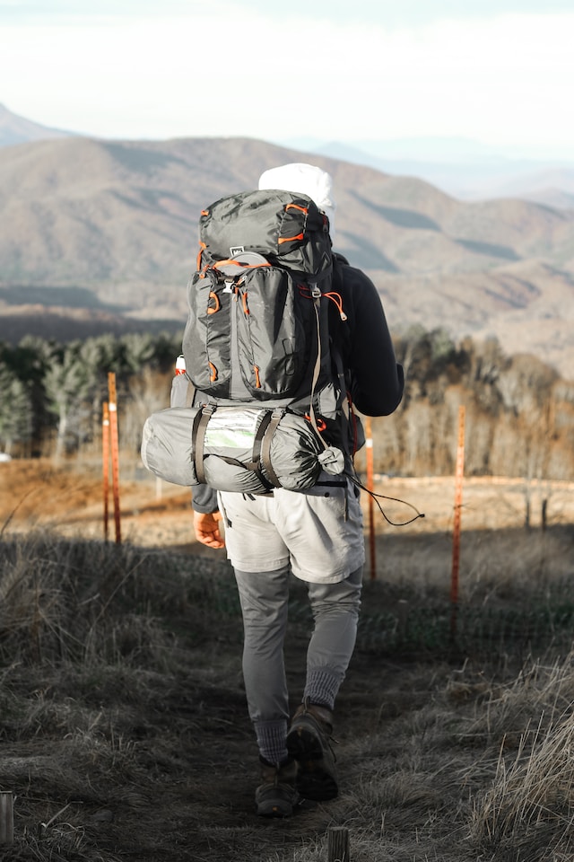 Hiking backpack with sleeping bag compartment and external attachments